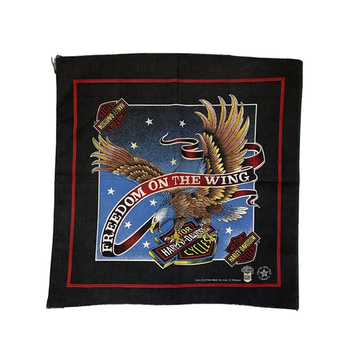 black harley davidson bandana with an eagle holding the harley davidson logo with a red boarder and blue background with white stars and a banner across the eagle saying freedom on the wing.